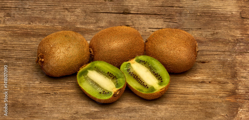 Fresh Group of Kiwi Fruits Full and Sliced on Wood Table Background, Rustic