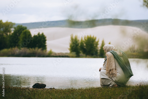 Jesus Christ thinking next to a body of water