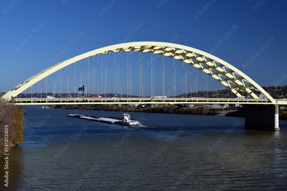 Boat on the Ohio river passing under the Big Mac bridge in Cincinnati