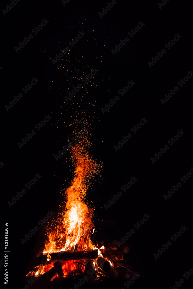 Campfire with flying sparks isolated on black background
