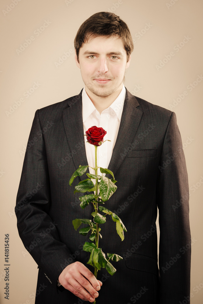 Elegant young man with red rose.