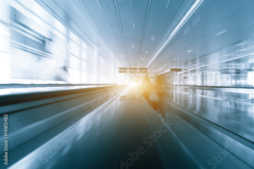 Abstract motion blured silhouette of a unrecognizable business travelers people at international airport moving to terminal gate for airplane travel trip