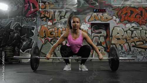 Fitness woman preparing to practice deadlift with heavy weights in gym. Female doing heavy weight lifting work out in health crossfit club, professional instructor. photo
