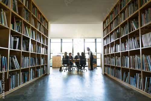 Background of modern creative design architectural office space boardroom meeting through bookshelves 