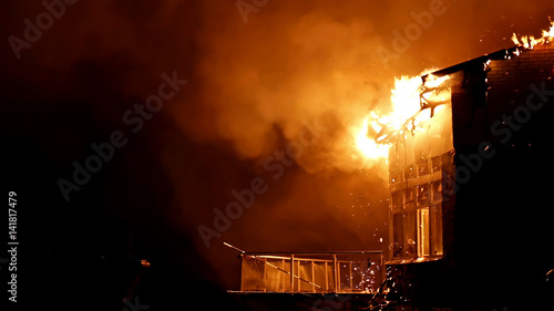 House building on fire at night. Inferno conflagration.