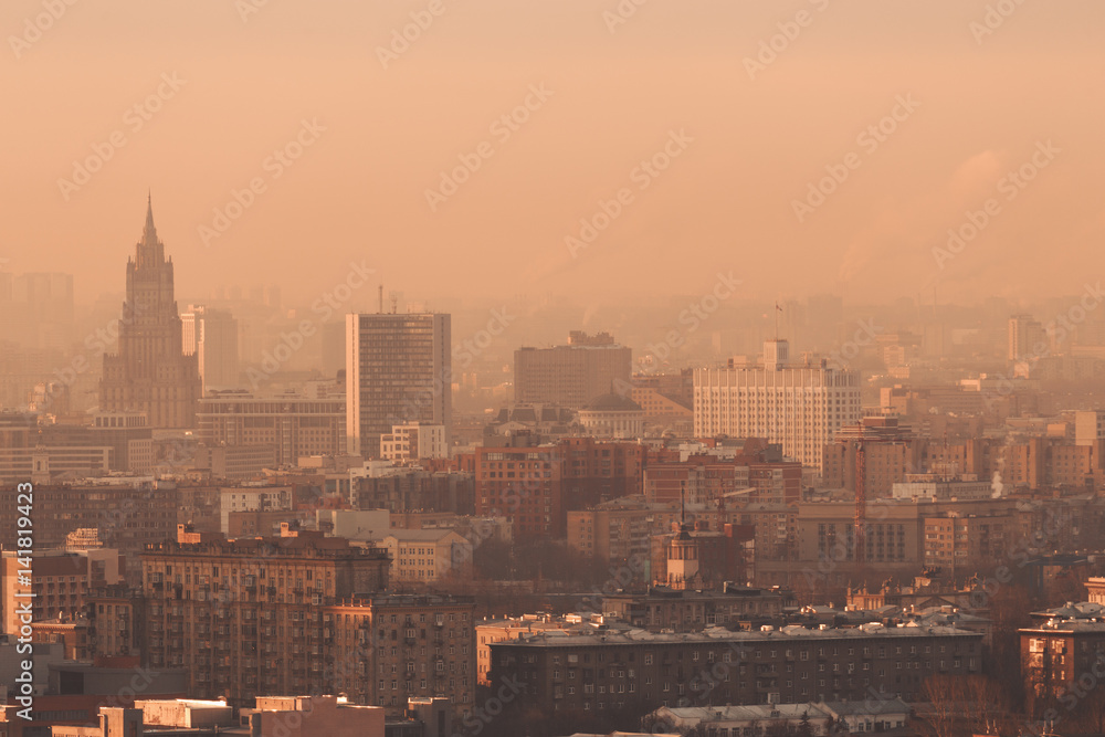 Close-up shooting from high point of metropolitan city: residential buildings and districts illuminated by morning sun, tower, multiple facades and windows, Government building, hazy horizon, Moscow