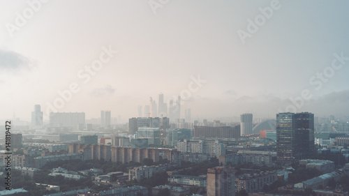 Hazy early morning metropolitan cityscape view from high point: residential and office buildings, "Moscow City" business skyscrapers group in distance