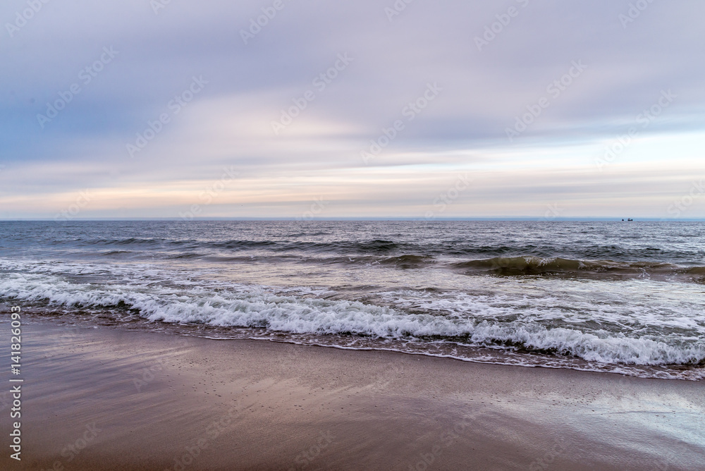 Waves on beach in sunset time. Baltic sea, Gdansk.
