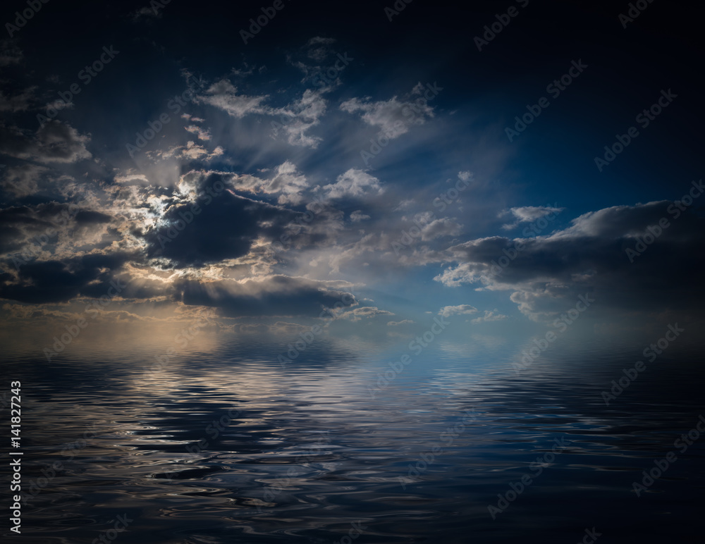 Dramatic sunset with clouds reflected in water.