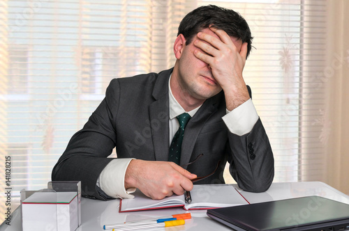 Depressed businessman with headache in the office