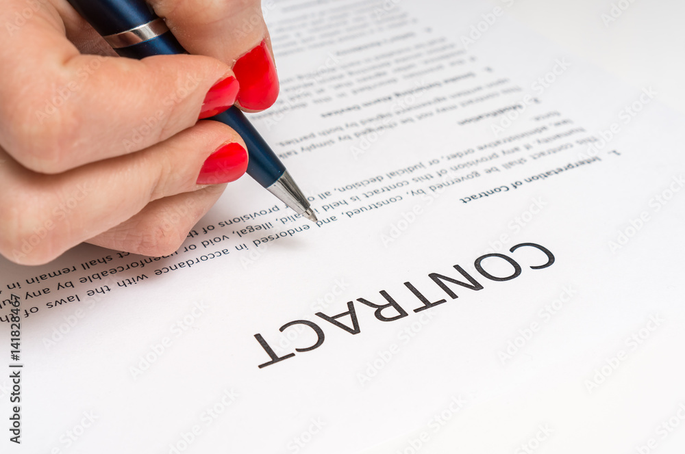 Business woman signing contract document in office Business woman signing contract document in office