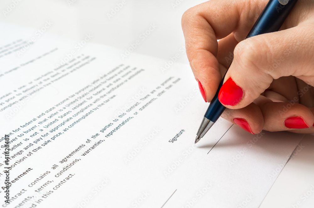 Woman with ballpoint pen signing contract document Woman with ballpoint pen signing contract document