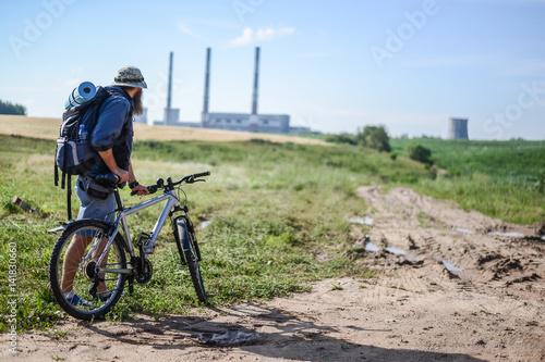 hipster man on a bicycle in the countryside