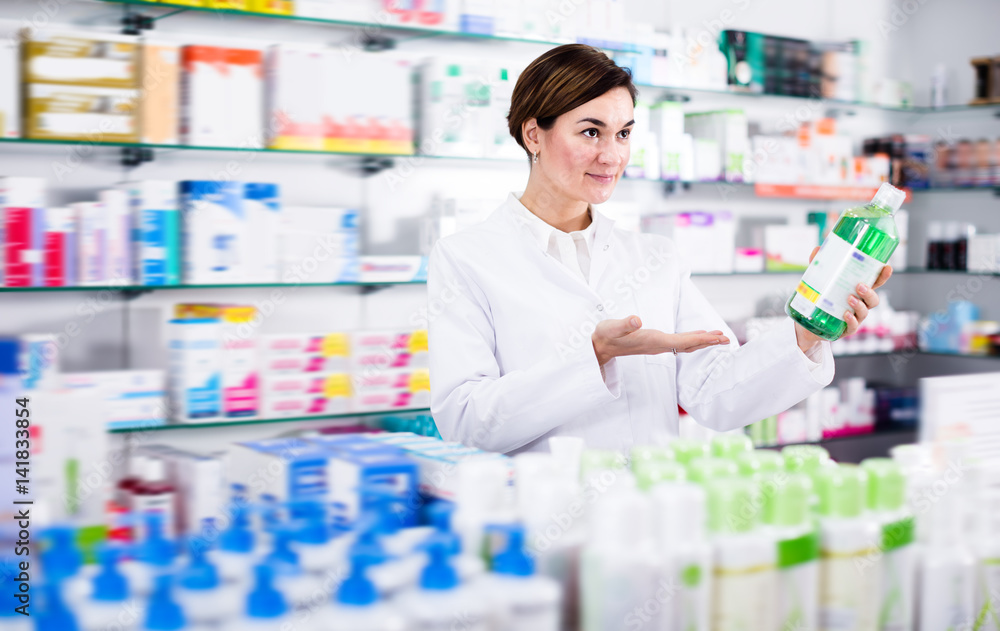 Cheerful female pharmacist offering products