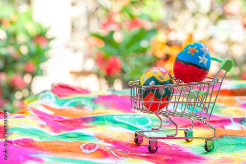 easter egg in shopping cart on colorful paper