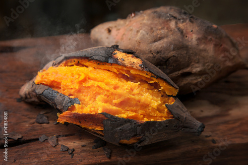 Delicious baked sweet potato on wooden table photo