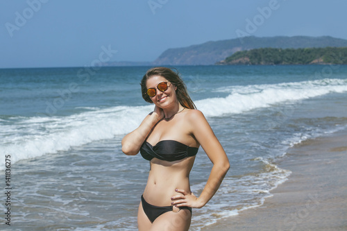 Beautiful happy young woman  on sandy ocean beach