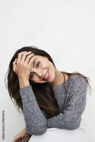 Smiling brunette woman in grey, portrait