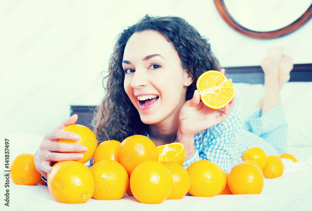 Positive girl eating oranges in bed Stock Photo Adobe Stock