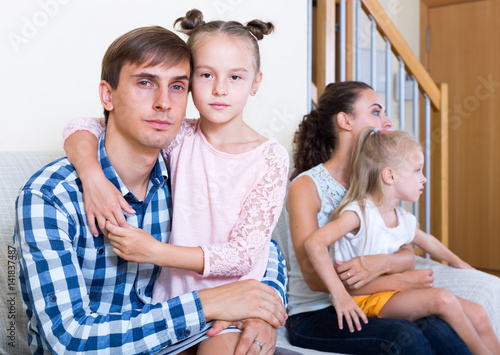 Sad spouses with two daughters photo