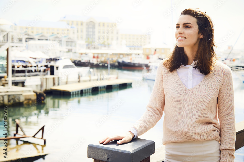 Fototapeta premium Beautiful woman at city waterfront, looking away