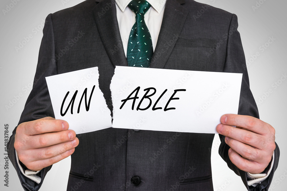 Businessman tearing paper with unable word Businessman tearing paper with unable word