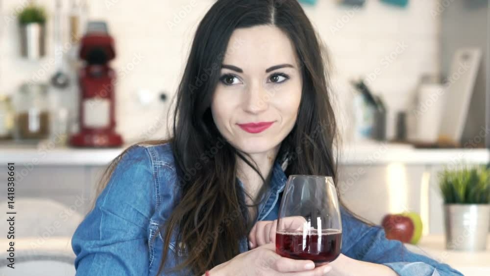 Young, happy woman relaxing on sofa drinking red wine at home
Young, happy woman relaxing on sofa drinking red wine at home