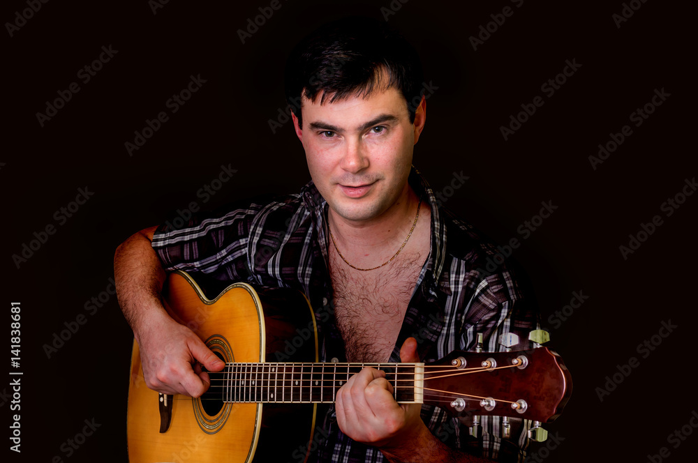 Obraz premium Young man playing acoustic guitar - isolated on black