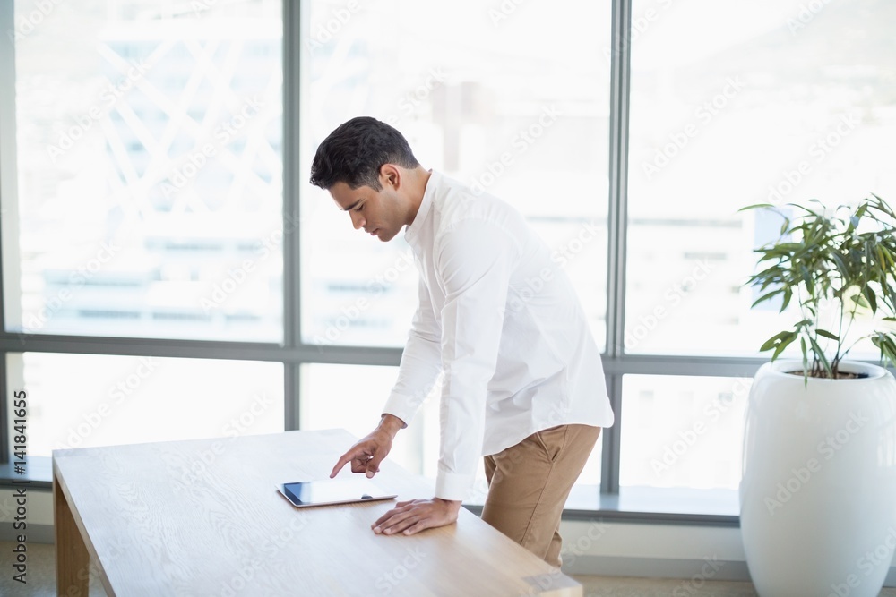 Business executive using digital tablet at desk Business executive using digital tablet at desk