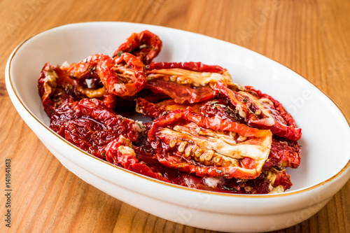 Dried tomatoes on wooden surface.