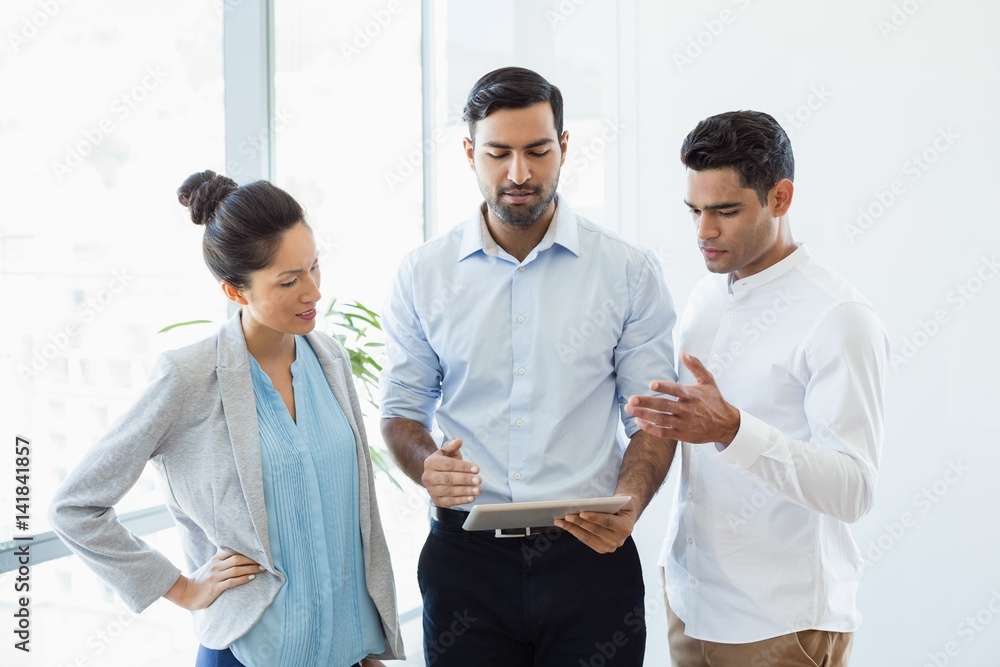 Business colleagues discussing over digital tablet in office
