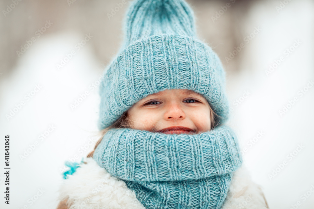 Portrait of beautiful happy girl in blue hat in winter snow park Portrait of beautiful happy girl in blue hat in winter snow park