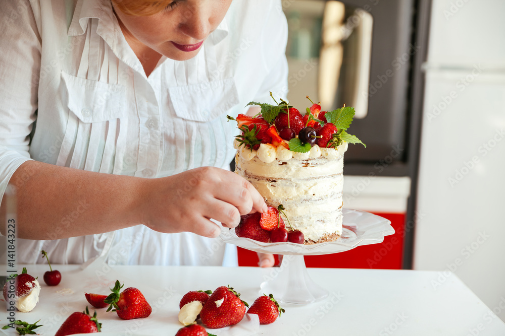Woman Carefully Icing The Cake Woman Carefully Icing The Cake