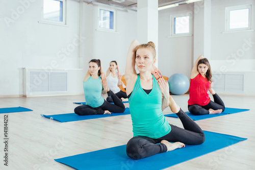 women are practicing yoga exercises in the studio. itness, sport, people and healthy lifestyle concept