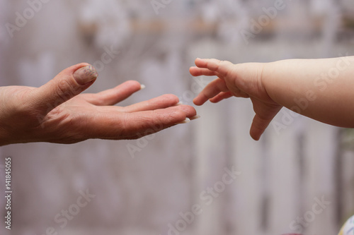 baby's hand reaching up to its photo