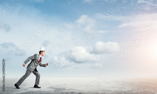 King businessman in elegant suit running and blue sky at background