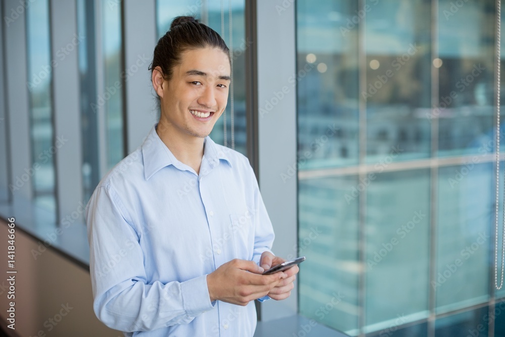 Business executive using on mobile phone in corridor Business executive using on mobile phone in corridor
