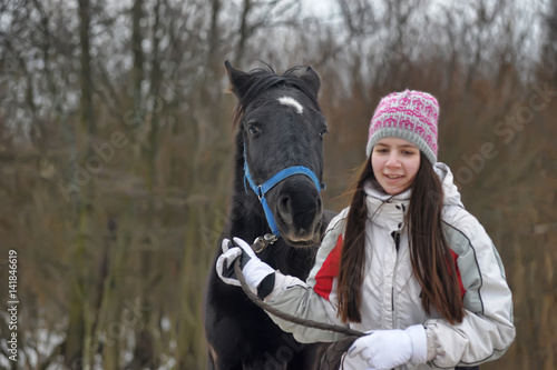 Pretty girl and horse in the winter fores photo
