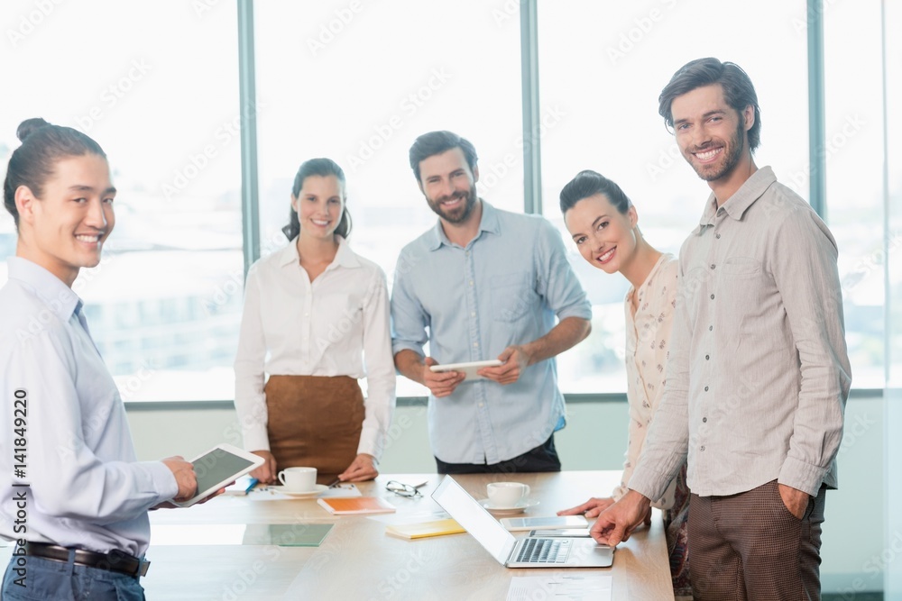 Smiling business executives standing in conference room