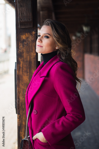 stylish young woman in pink coat on the street © shapovalphoto