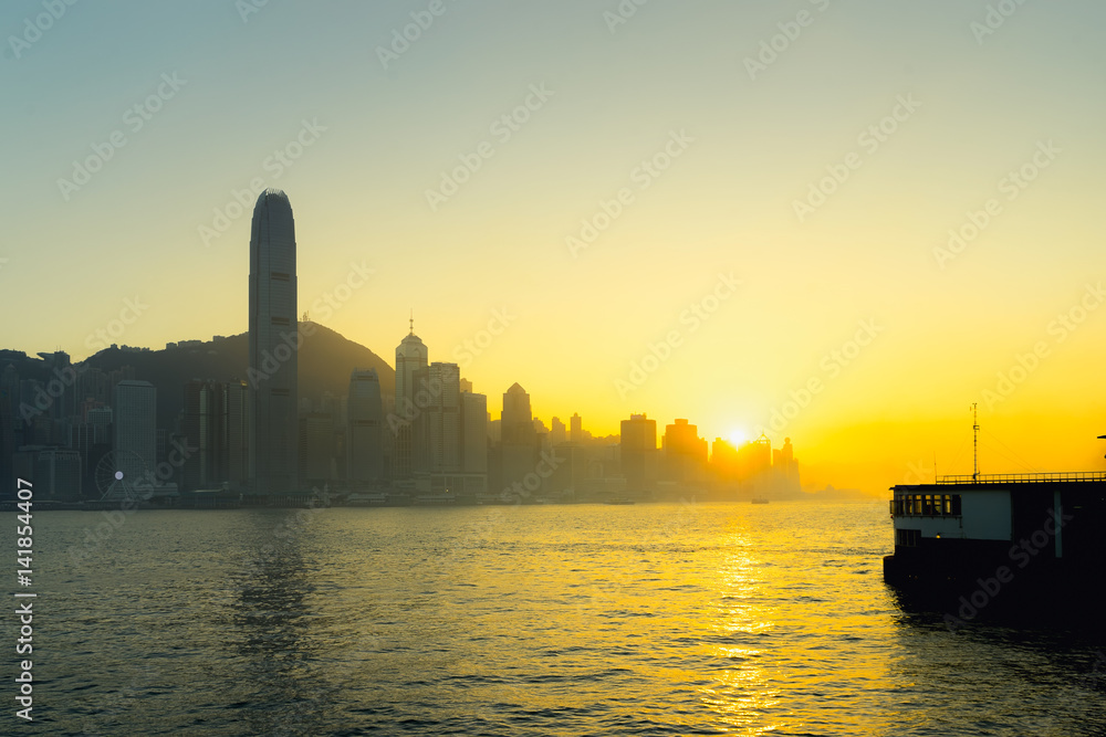 Fototapeta premium Victoria Harbour skyline in Hong Kong at twilight, illuminated skyscrapers and waterfront cityscape forming an iconic Asian financial district, urban landmark and international travel.