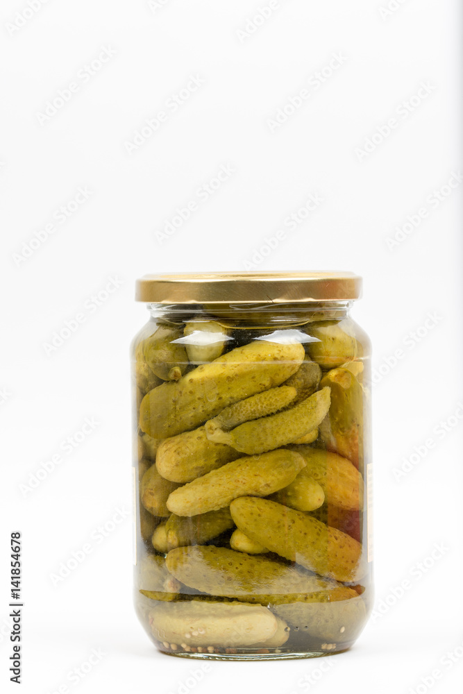 Small pickles in the jar isolated over white background Small pickles in the jar isolated over white background