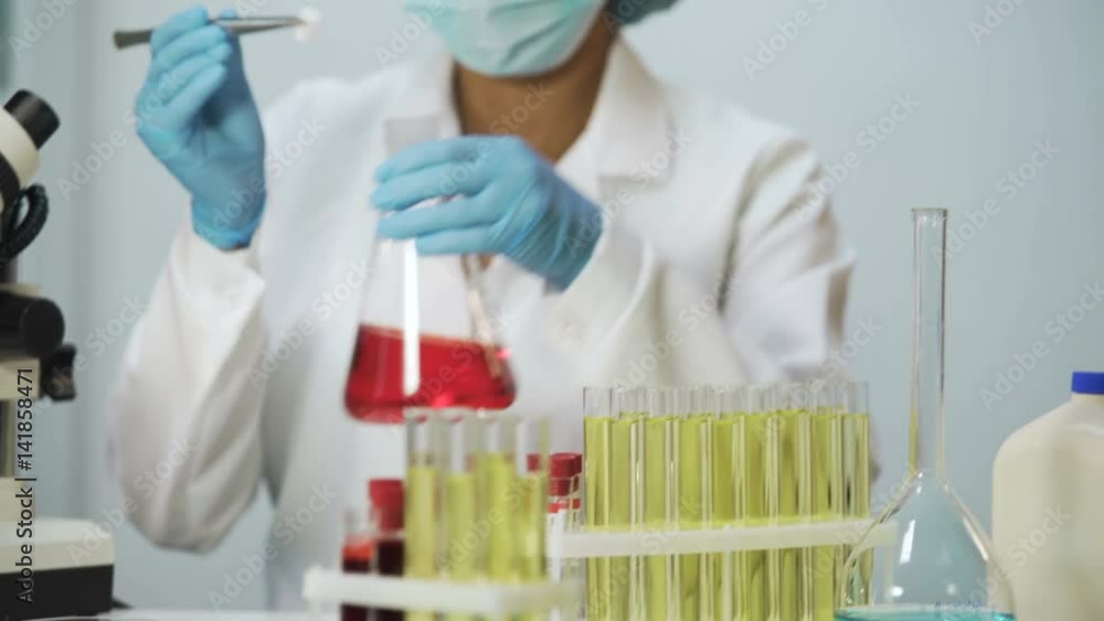 Chemical reaction in Erlenmeyer flask, lab assistant doing cosmetology research Chemical reaction in Erlenmeyer flask, lab assistant doing cosmetology research