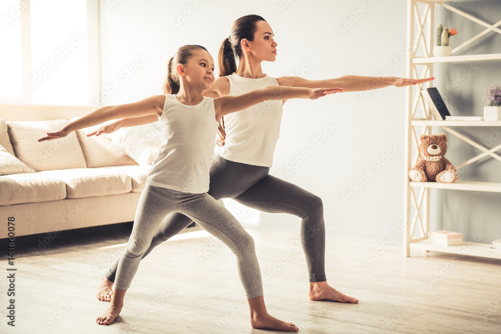 Fototapeta premium Mom and daughter doing yoga