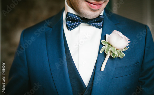 Groom in a blue suit with a bow tie