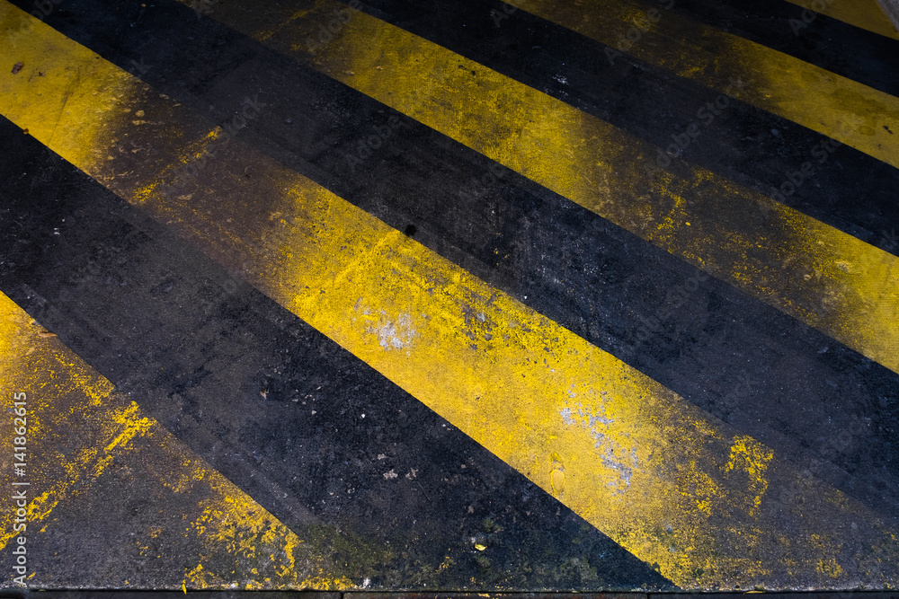 Fototapeta premium zebra hachure entrée sortie zone réservée jaune garage emplacement place peinture sol béton quai signalétique matière