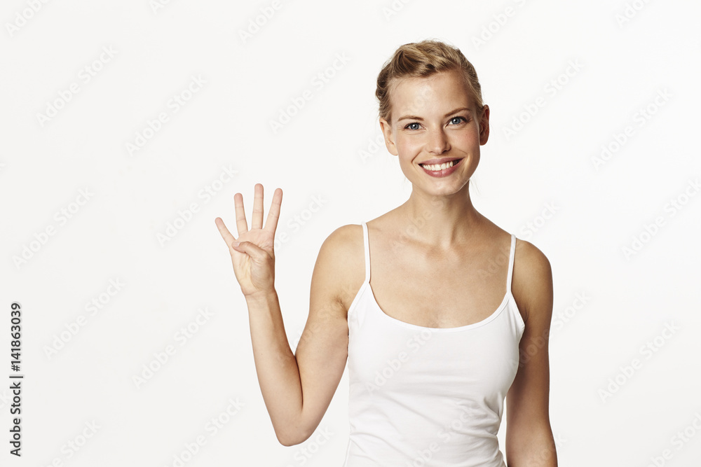 Stunning woman holding up four fingers, portrait Stunning woman holding up four fingers, portrait
