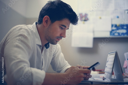 Businessman using smart phone in the office.