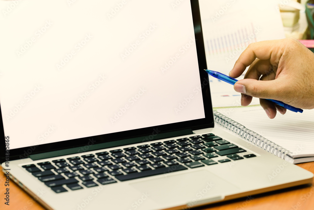 Businessman hands use pen pointing to laptop screen with copy space. (Vintage tone) Businessman hands use pen pointing to laptop screen with copy space. (Vintage tone)