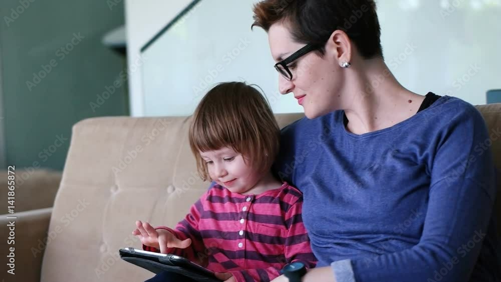 Mother teaches daighter how to use digital tablet Mother teaches daighter how to use digital tablet